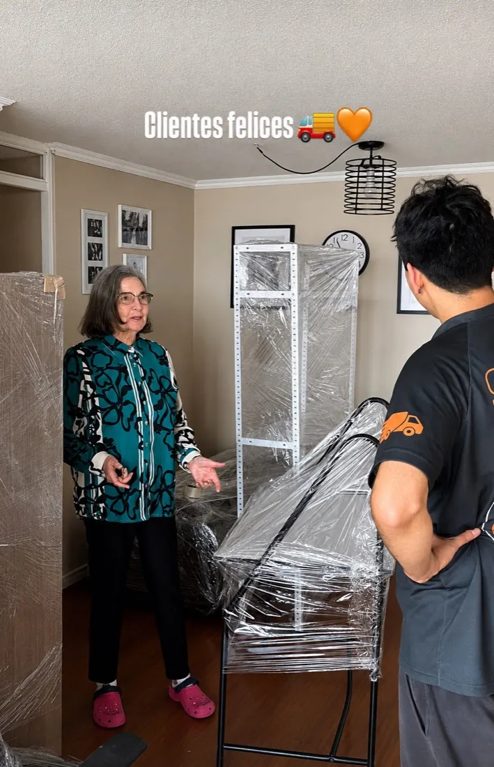 Clienta de Yoru Express conversando con un trabajador junto a muebles embalados para la mudanza
