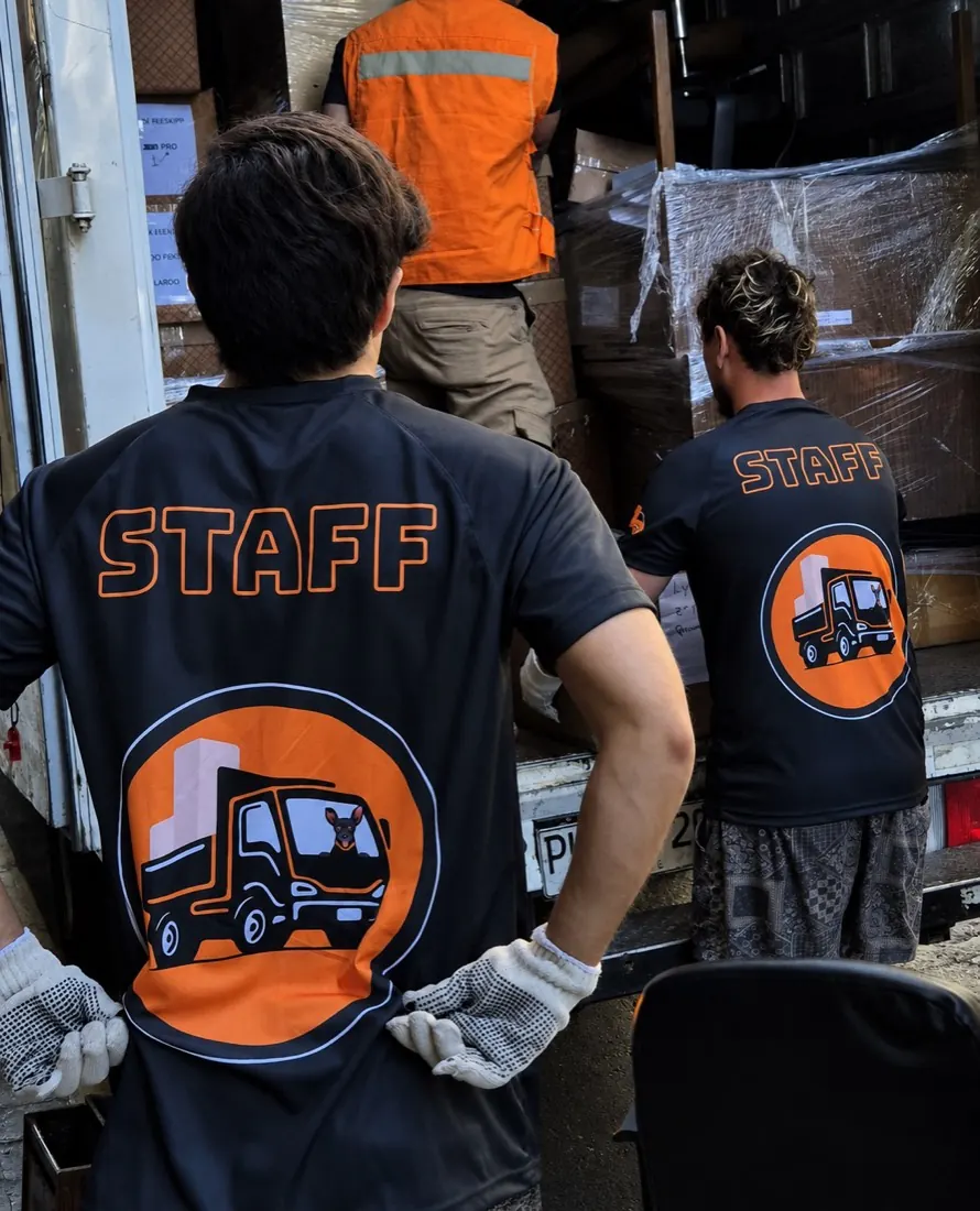 Trabajadores de Yoru Express con poleras STAFF cargando cajas dentro de un camión de mudanza