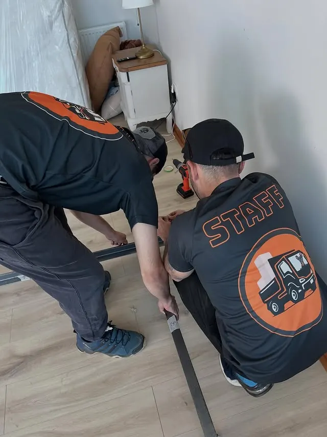 Trabajadores de Yoru Express armando un mueble durante una mudanza
