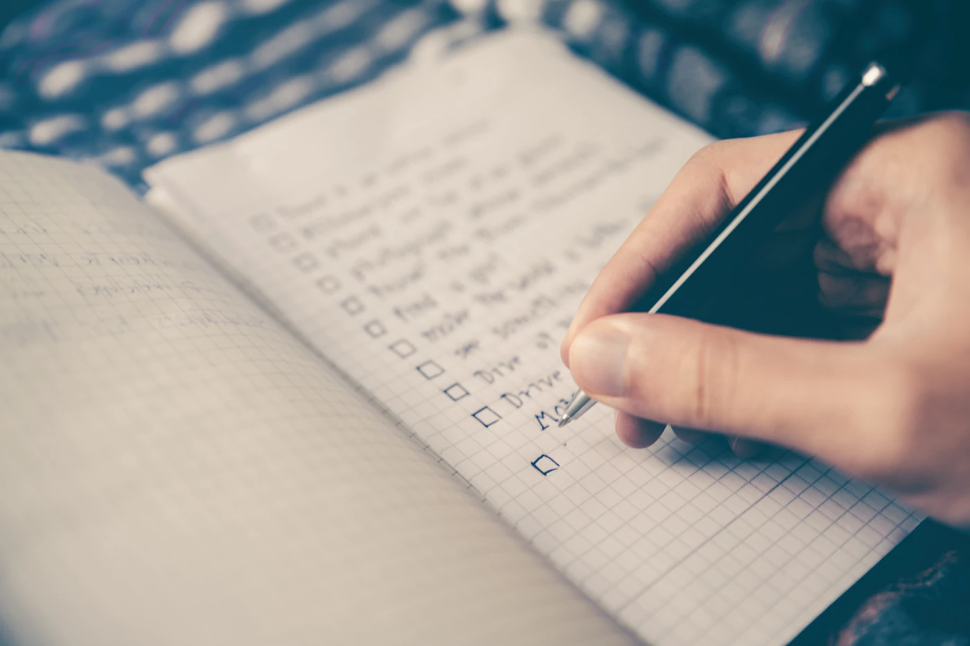 Persona escribiendo una lista de tareas con casilleros para marcar