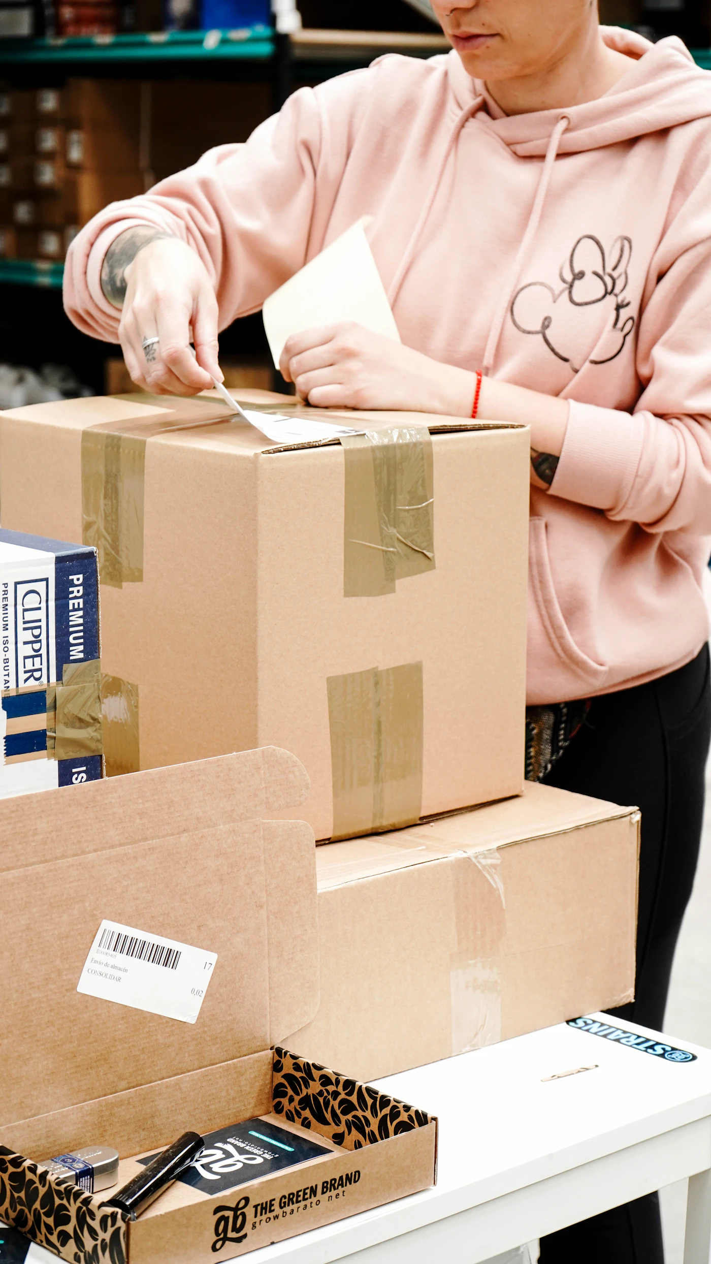 Persona etiquetando y sellando una caja de mudanza con cinta